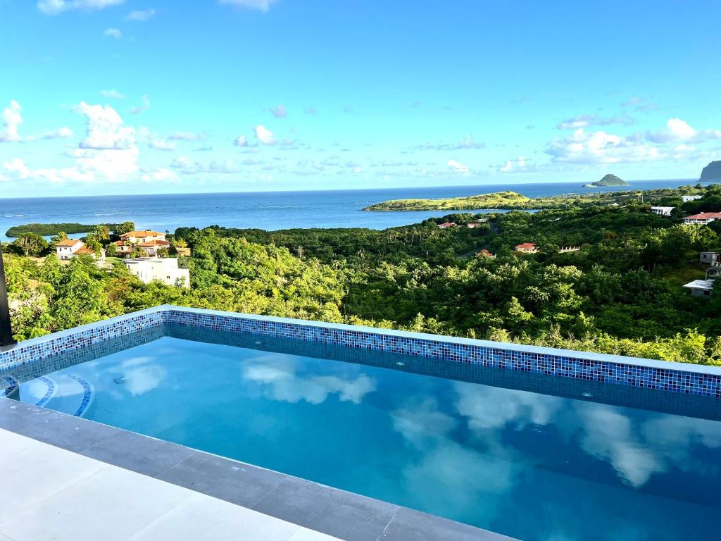 a swimming pool with a view of the ocean at The Luxury Escape in Rouarné