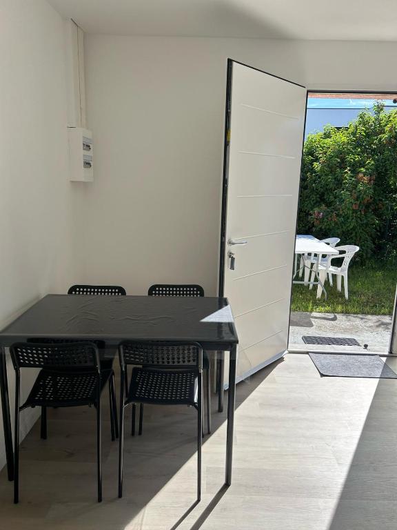 a black table and chairs in a room with a door at Au Trèfle Dort in Châtel-Guyon