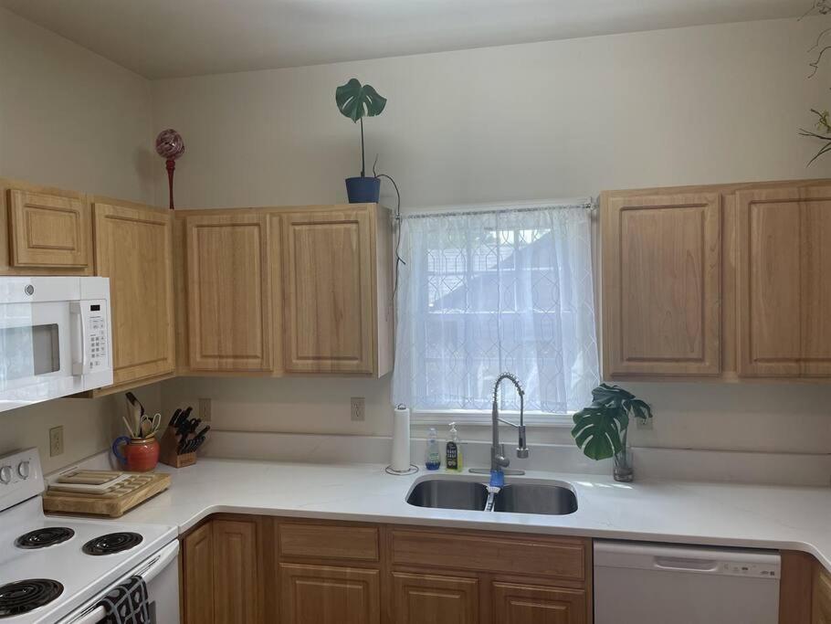 a kitchen with a sink and a microwave at Entire 3B 2Ba Home- Close to Everything in Durham! in Durham
