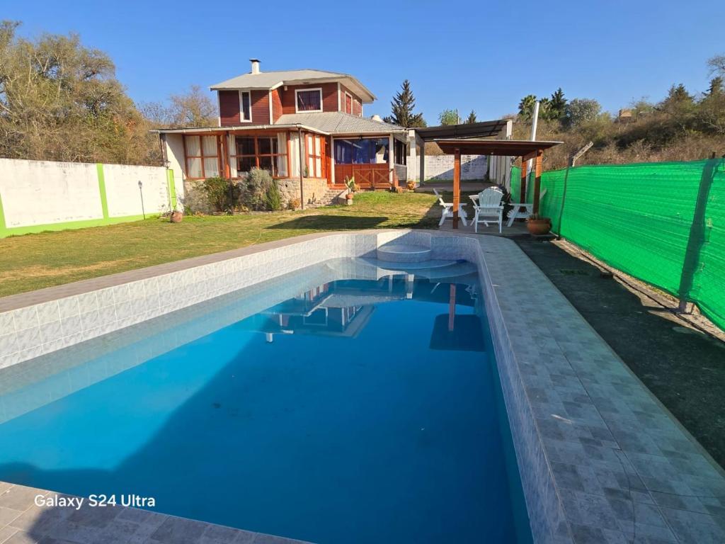 a swimming pool in front of a house at Cabaña en el Dique de la cienaga in El Carmen