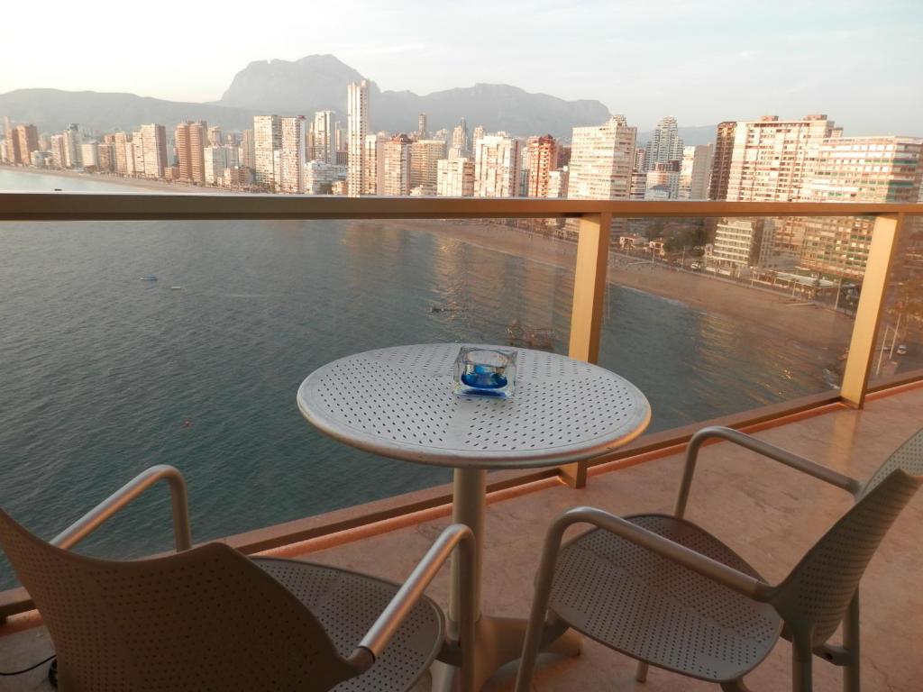 ベニドルムにあるParaiso Lido-Fincas Benidormのテーブルと椅子、水辺を見渡すバルコニー