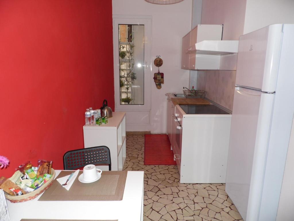 パドヴァにあるCasa Piazza del Santoの赤い壁のキッチン(白い冷蔵庫付)