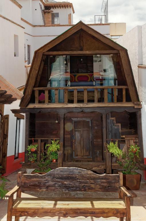 a small wooden house with a bench in front of it at troje tradicional purépecha -live the experince- in Morelia