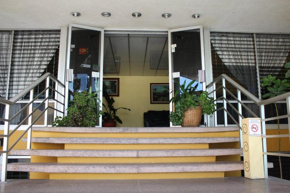 eine Treppe vor einem Gebäude mit Topfpflanzen in der Unterkunft Hotel Dinastía Colima in Colima