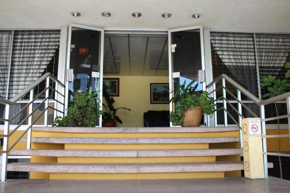 a staircase in front of a building with potted plants at Hotel Dinastía Colima in Colima