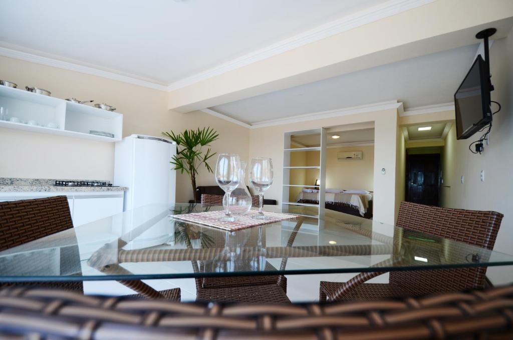 a dining room with a glass table and chairs at Flat Vila 4 Amigos in Natal