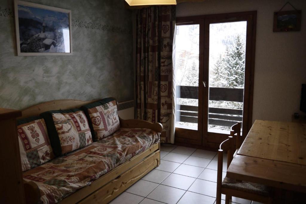 un salon avec un canapé, une table et une fenêtre dans l'établissement Résidence Proveres - PROVERES 15 MAE-4131, à Les Allues