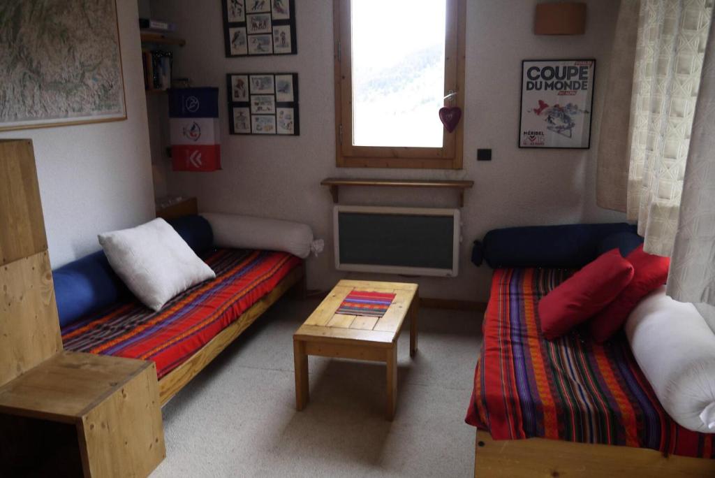 une petite chambre avec deux lits et une télévision dans l'établissement Résidence Arc En Ciel - ARC EN CIEL G12<br /> MAE-4181, à Les Allues