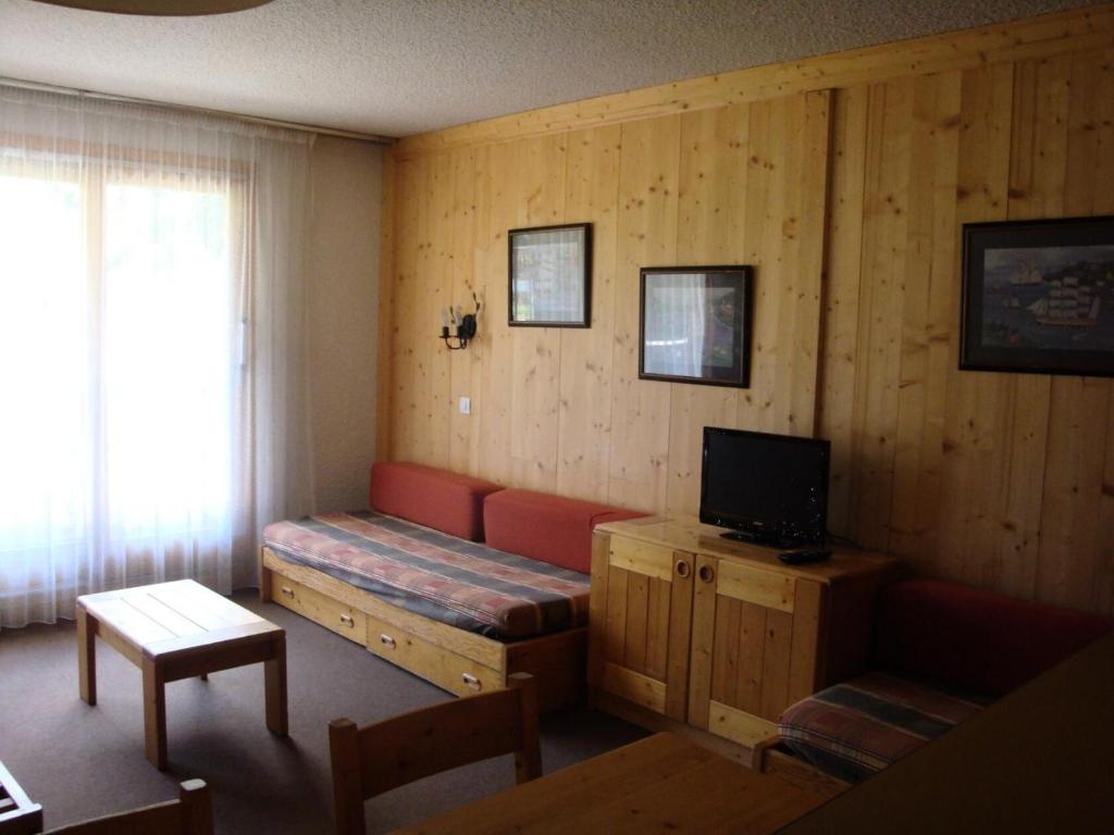 un salon avec un canapé et une télévision dans l'établissement Résidence Arpasson - ARPASSON 18 MAE-4401, à Les Allues