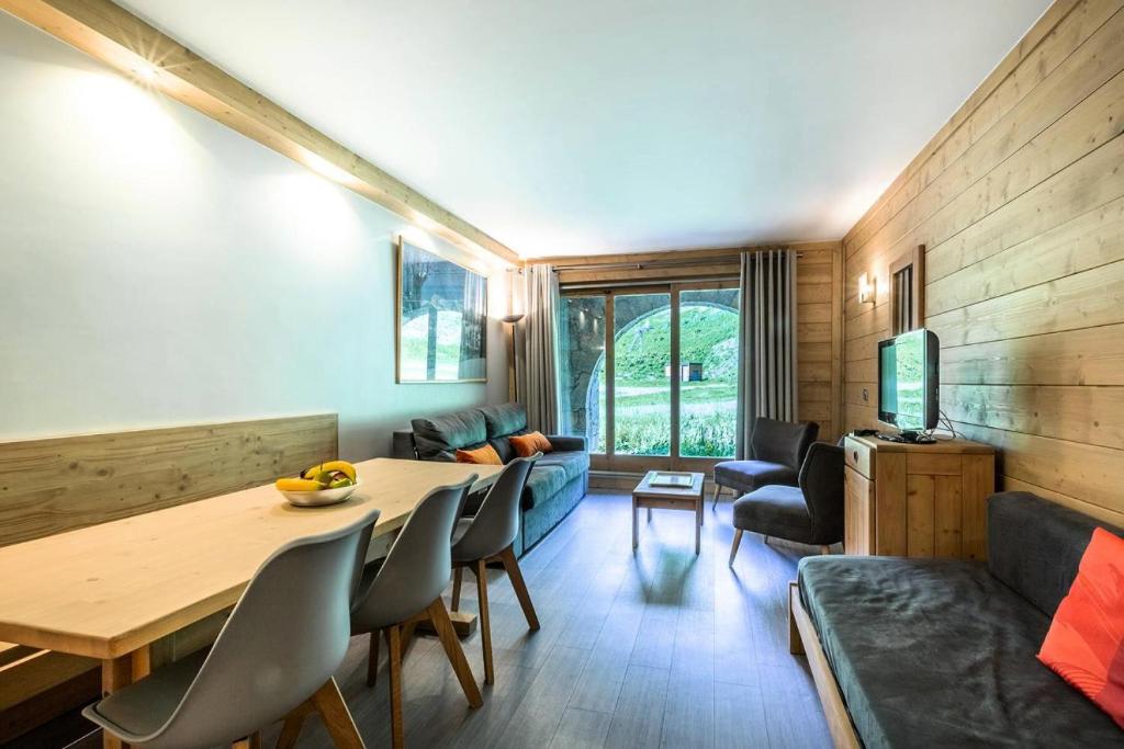 un salon avec une table et un canapé dans l'établissement Résidence Arpasson - ARPASSON 22 MAE-4411, à Les Allues