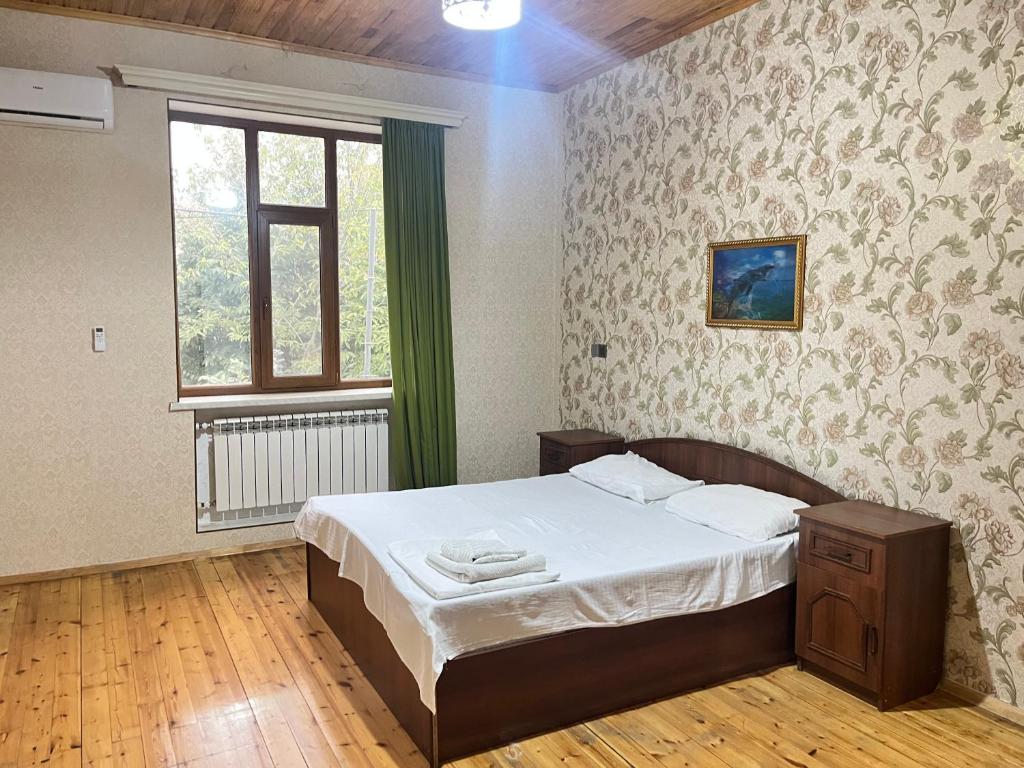 un dormitorio con una cama y una ventana en Qabala KOMFORT Villa, en Gabala
