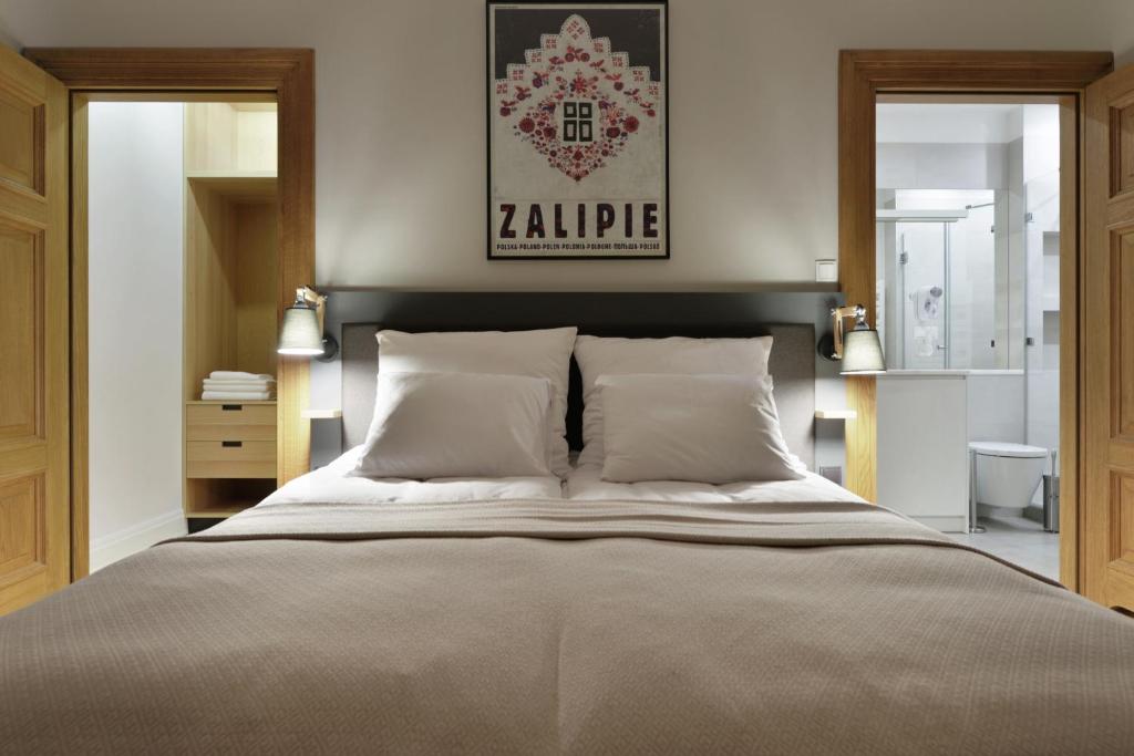 een slaapkamer met een groot bed en 2 spiegels bij STRADONIA Serviced Apartments in Krakau