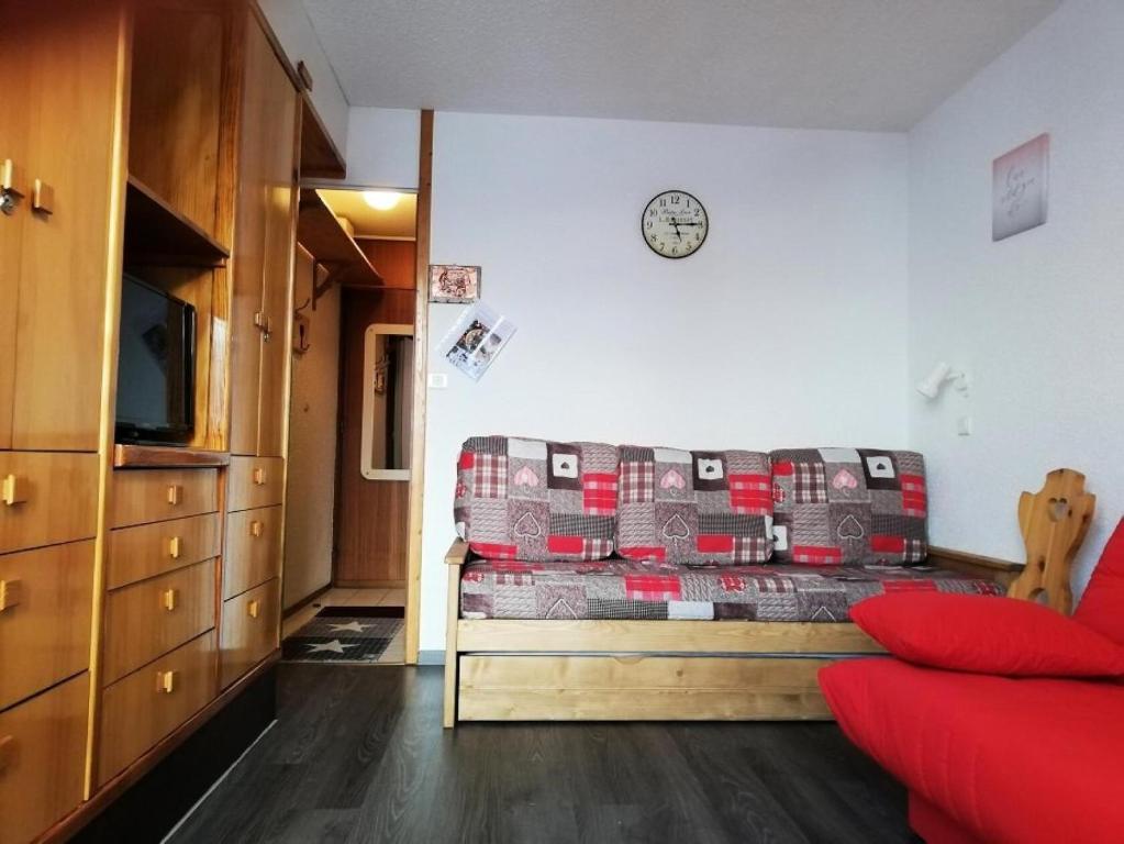 un salon avec un canapé et une horloge au mur dans l'établissement Résidence Les Hameaux I - Résidence LES HAMEAUX I N°268 MAE-4981, à La Plagne Tarentaise