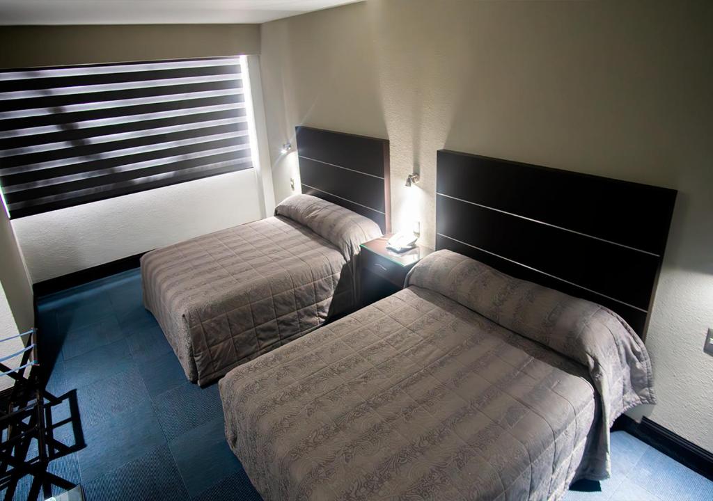 Postel nebo postele na pokoji v ubytování Hotel Parque Satelite