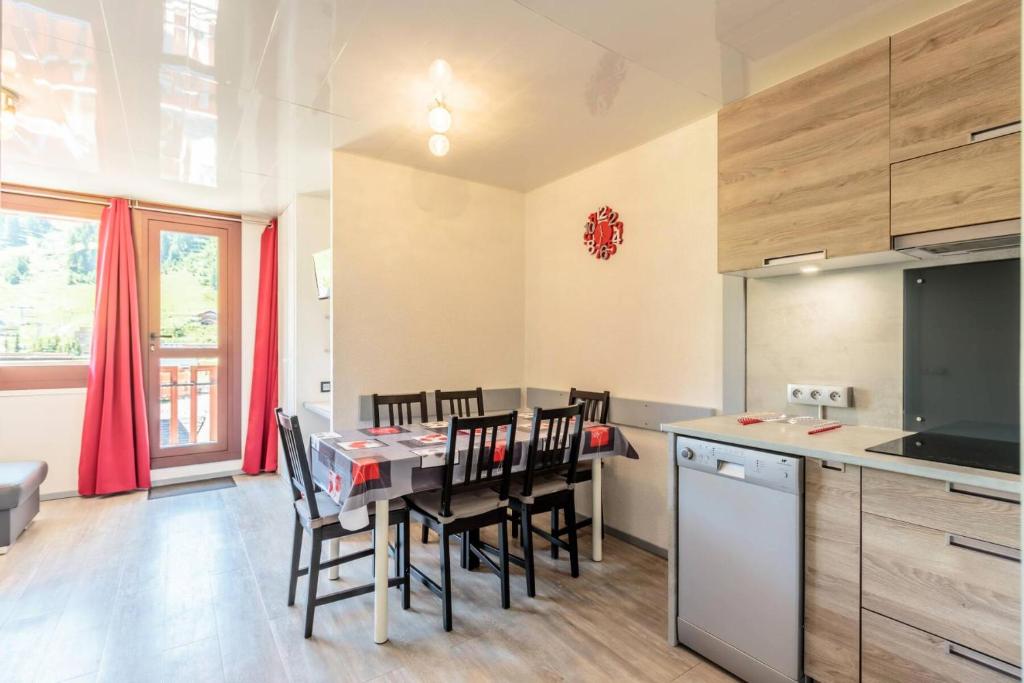 une cuisine et une salle à manger avec une table et des chaises dans l'établissement Résidence Saint Jacques - Résidence LE SAINT JACQUES A N°103 MAE-5071, à La Plagne Tarentaise