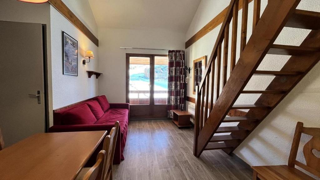 - un salon avec un canapé rouge et un escalier dans l'établissement Résidence Le Cervin - Résidence LE CERVIN N°417 MAE-5501, à La Plagne Tarentaise