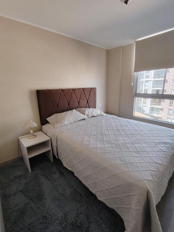 a bedroom with a large bed and a window at Apartamento de estreno in Arequipa