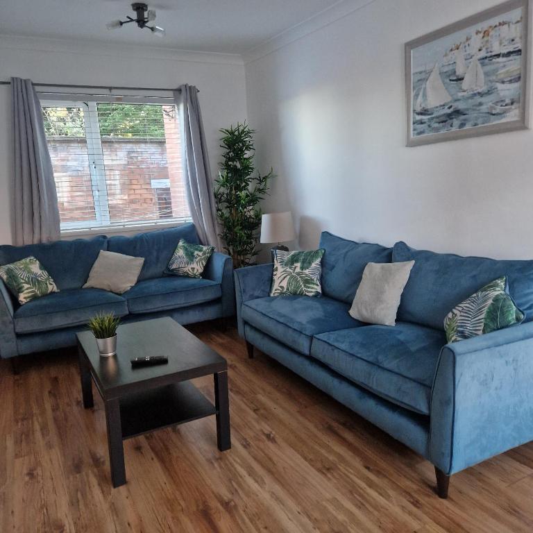 Una sala de estar con un sofá azul y una mesa. en Belfast Central house, en Belfast
