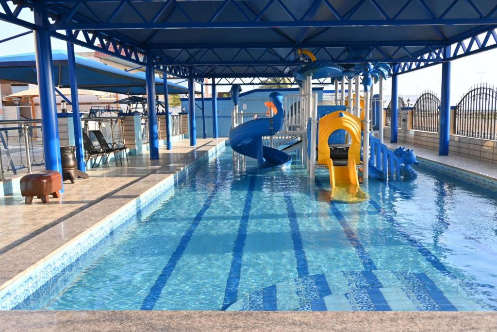 a swimming pool with a slide in the water at شاطئ العرب الرايس in Rayyis