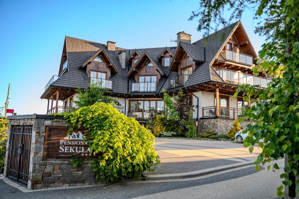 a large house with a sign in front of it at Pensjonat Sekuła*** in Bukowina Tatrzańska