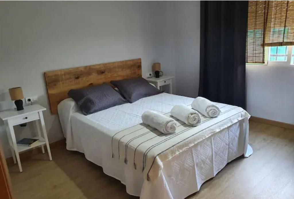 ein Schlafzimmer mit einem großen weißen Bett mit Handtüchern darauf in der Unterkunft Casa rural en Padul entre Sierra Nevada y la Costa in Granada