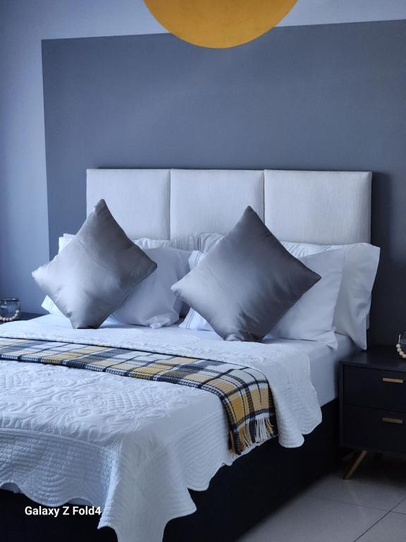 a bedroom with a bed with blue walls and pillows at Sunshine Inn in Gaborone