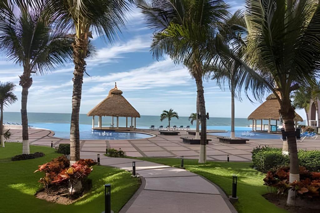 uitzicht op een strand met palmbomen en een prieel bij Gavias Grand Cerritos in Mazatlán