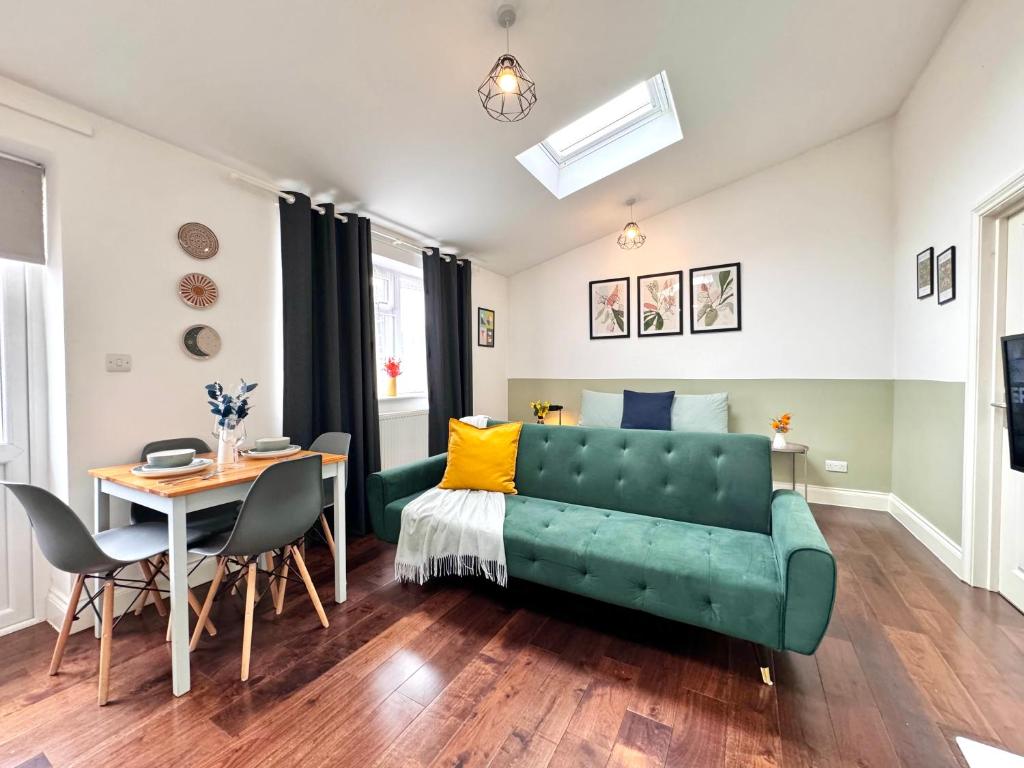 Hotel Alluring Studio 30min to Central London & Free Parking, a living room with a green couch and a table at Alluring Studio 30min to Central London & Free Parking in London