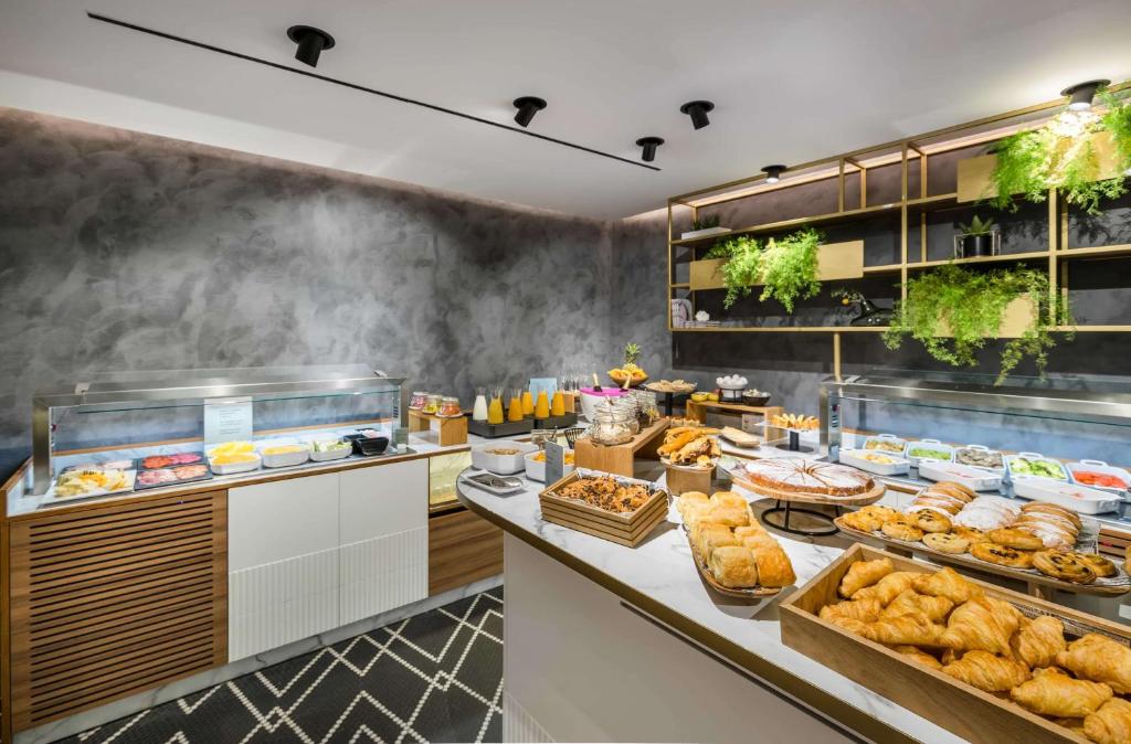 a buffet line with bread and pastries in a restaurant at Occidental Alicante in Alicante