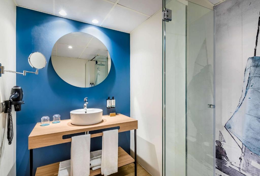 a bathroom with a sink and a mirror at Occidental Alicante in Alicante