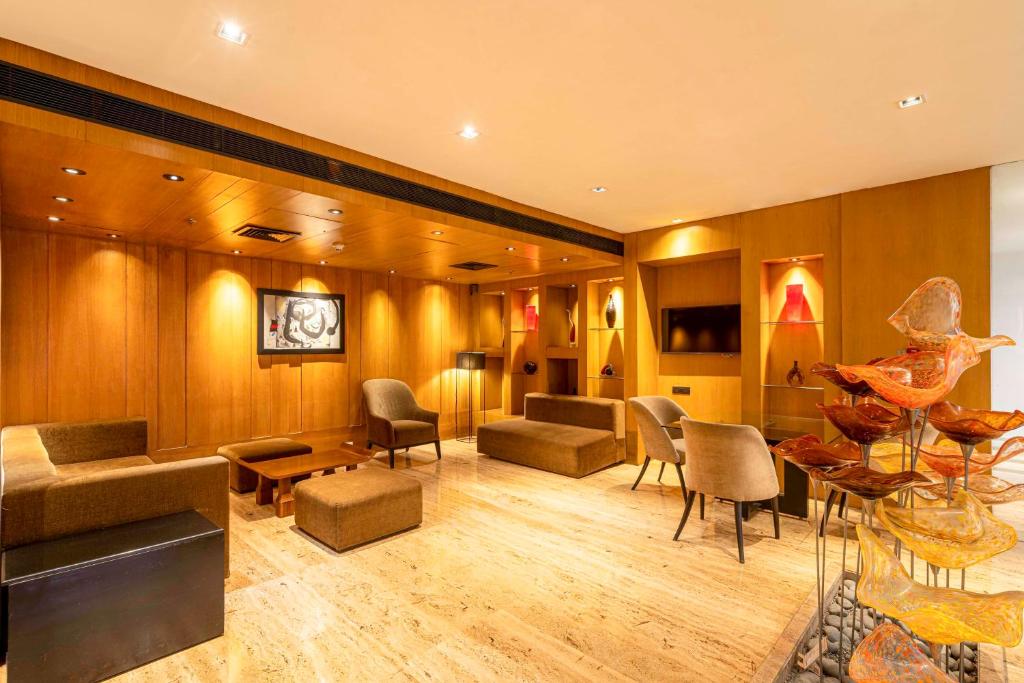 a living room with chairs and a couch and tables at Svelte Delhi, a member of Radisson Individuals in New Delhi