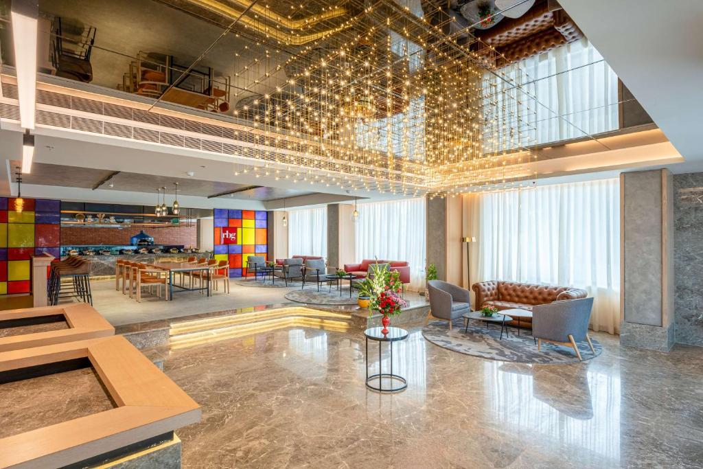 a lobby with chairs and tables in a building at Park Inn by Radisson Vellore in Vellore