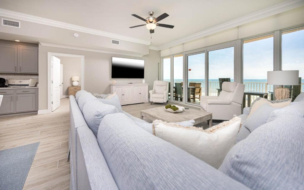 a living room with a large couch and a kitchen at Phoenix Gulf Towers 405 condo in Gulf Shores