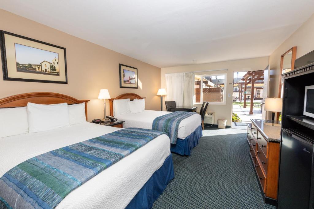 a hotel room with two beds and a flat screen tv at Pea Soup Andersen's Inn in Buellton