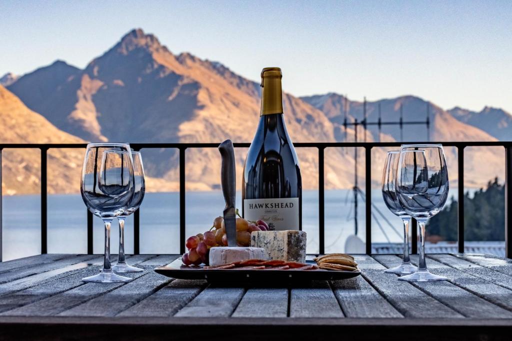 クイーンズタウンにあるSpacious Central Executive 4 Bedroom Apartmentのワイン1本とグラス2杯付きのテーブル