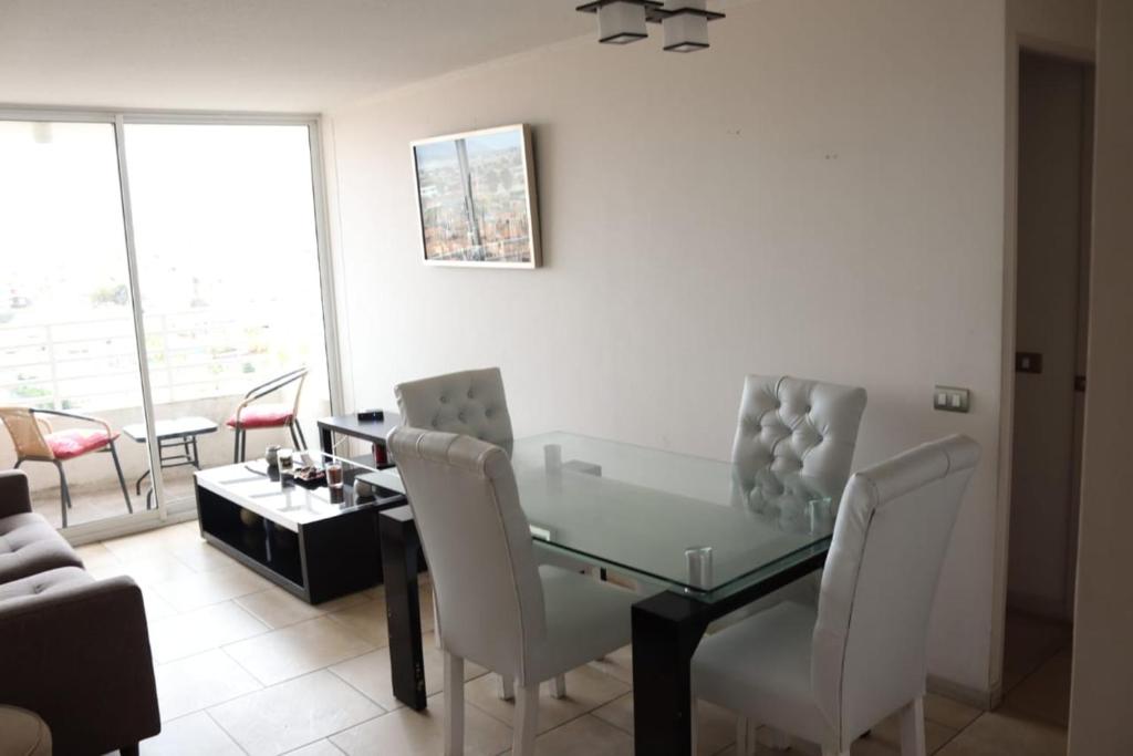 un soggiorno con tavolo e sedie in vetro di Departamento con 3 habitaciones para 4 personas playa la Herradura a Coquimbo