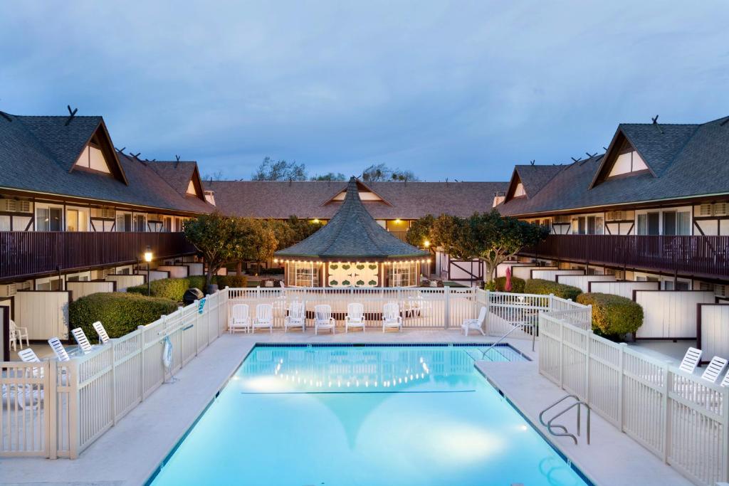 a pool at a hotel with chairs and a resort at Pea Soup Andersen's Inn in Buellton