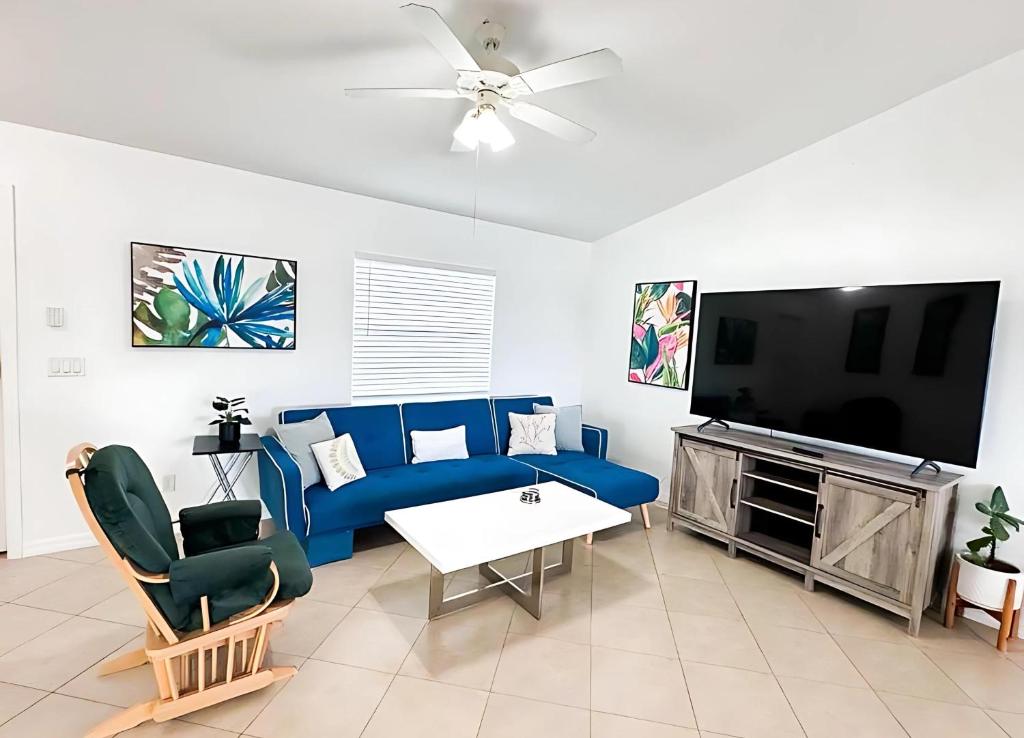 a living room with a blue couch and a flat screen tv at Experience Fun Starts Here w Pool & Wifi in Port Charlotte