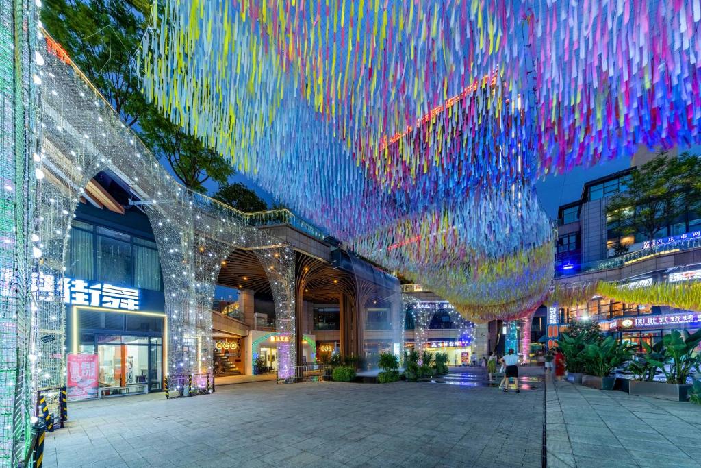 a building with a bunch of colorful lights hanging from it at Wuyu Hotel - Chongqing Jiangbei Airport & Light Rail in Chongqing