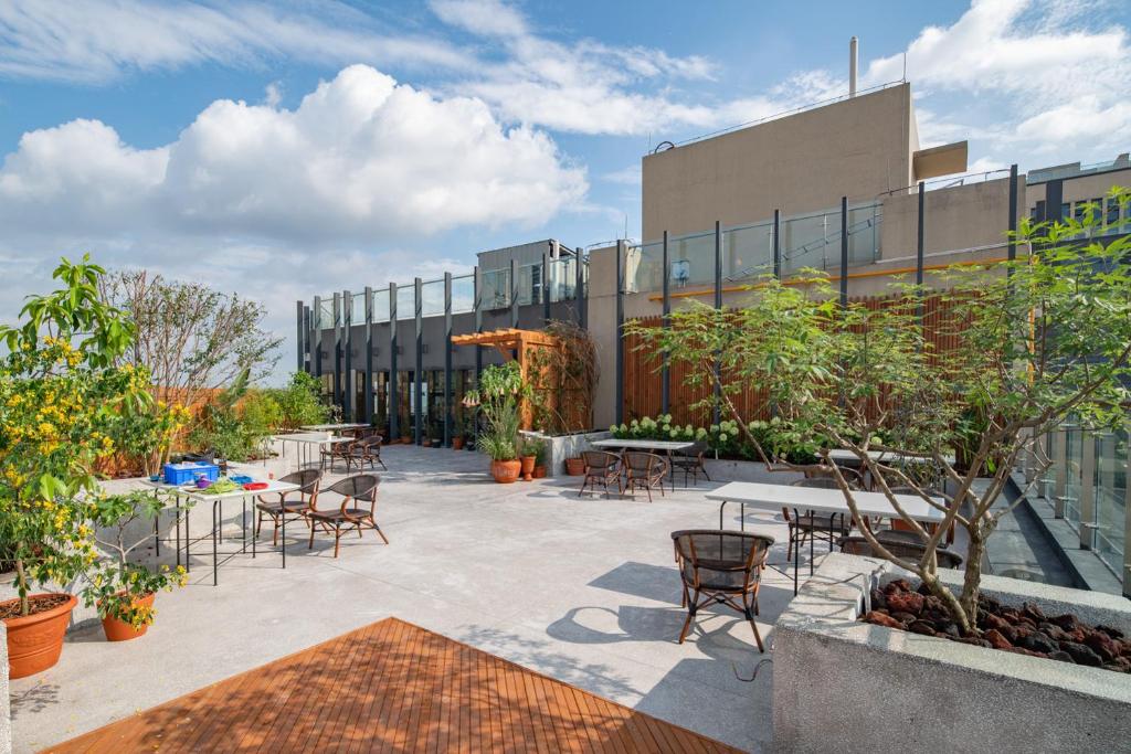 a courtyard with tables and chairs in front of a building at Wuyu Hotel - Chongqing Jiangbei Airport & Light Rail in Chongqing
