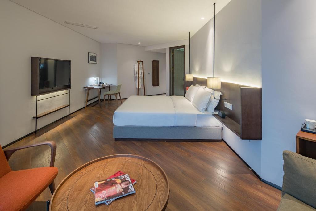 a hotel room with a bed and a table at Wuyu Hotel - Chongqing Jiangbei Airport & Light Rail in Chongqing