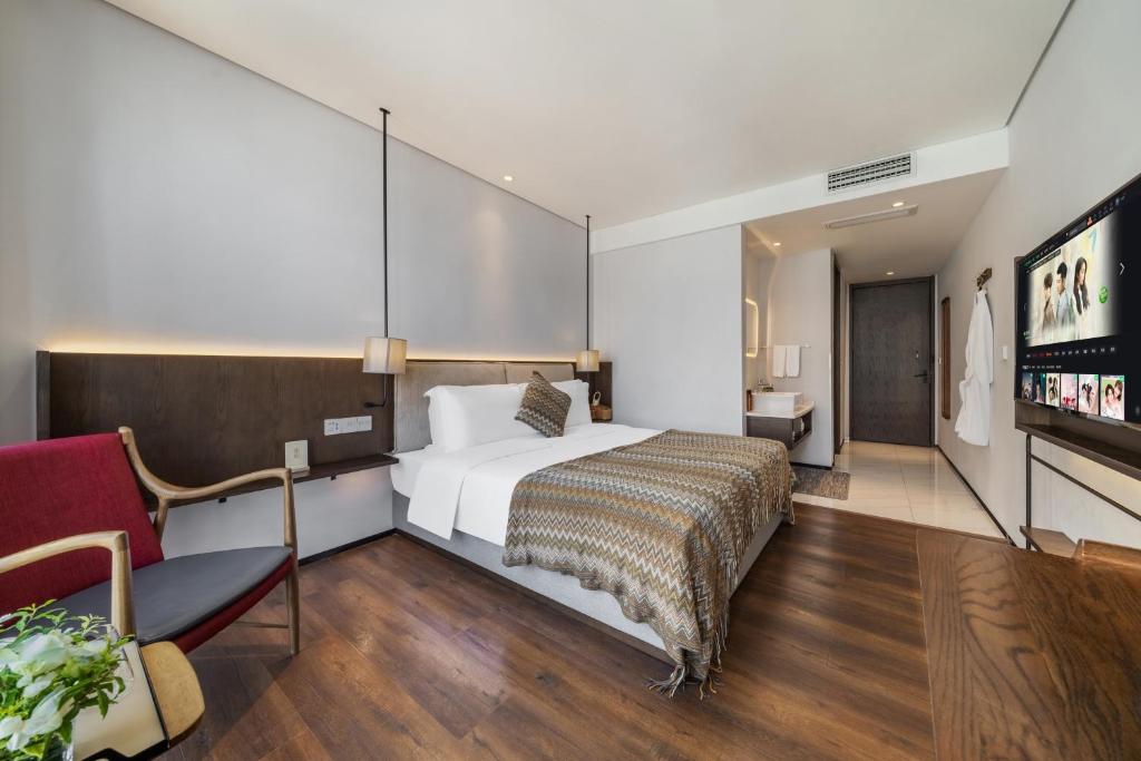 a hotel room with a bed and a tv at Wuyu Hotel - Chongqing Jiangbei Airport & Light Rail in Chongqing