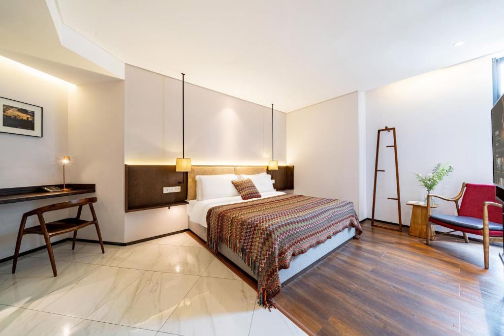 a bedroom with a bed and a desk and a desk at Wuyu Hotel - Chongqing Jiangbei Airport & Light Rail in Chongqing