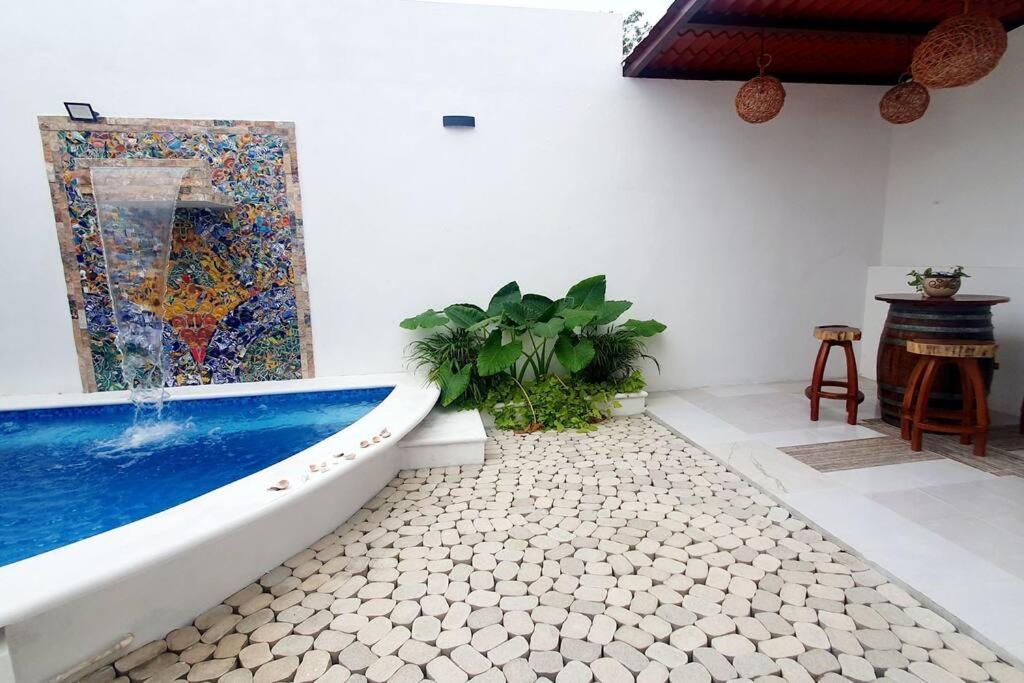 a bathroom with a bath tub and a painting on the wall at Casa Girasoles Valladolid Yucatán in Santa Bárbara