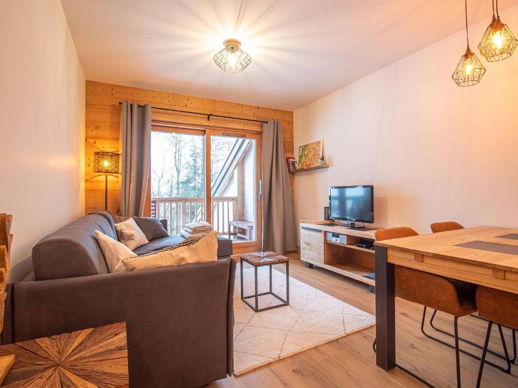 un salon avec un canapé et une télévision dans l'établissement Valmorel: Appt 6 pers, 2 ch, parking, wifi, skis aux pieds - FR-1-356-511, à Valmorel
