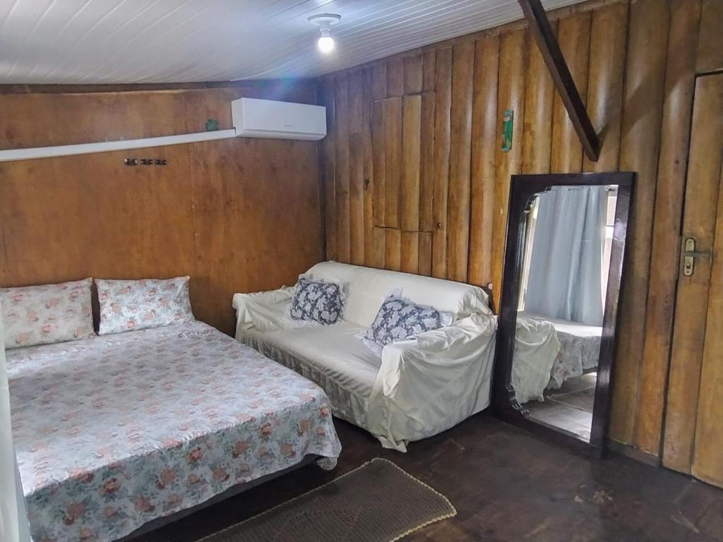 a small bedroom with a bed and a mirror at Loft frente ao mar para 6 pessoas na Ilha do mel in Ilha do Mel