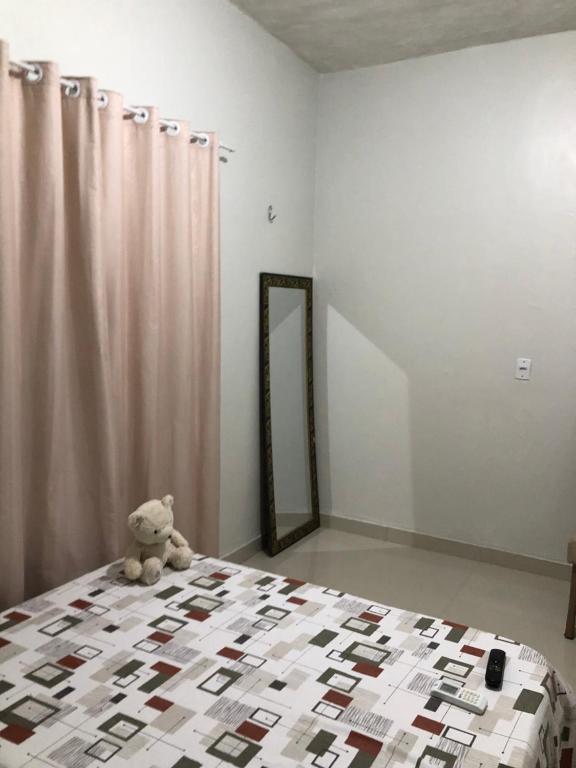 a teddy bear sitting on a bed in a bedroom at Festival de Parintins -2025 in Parintins