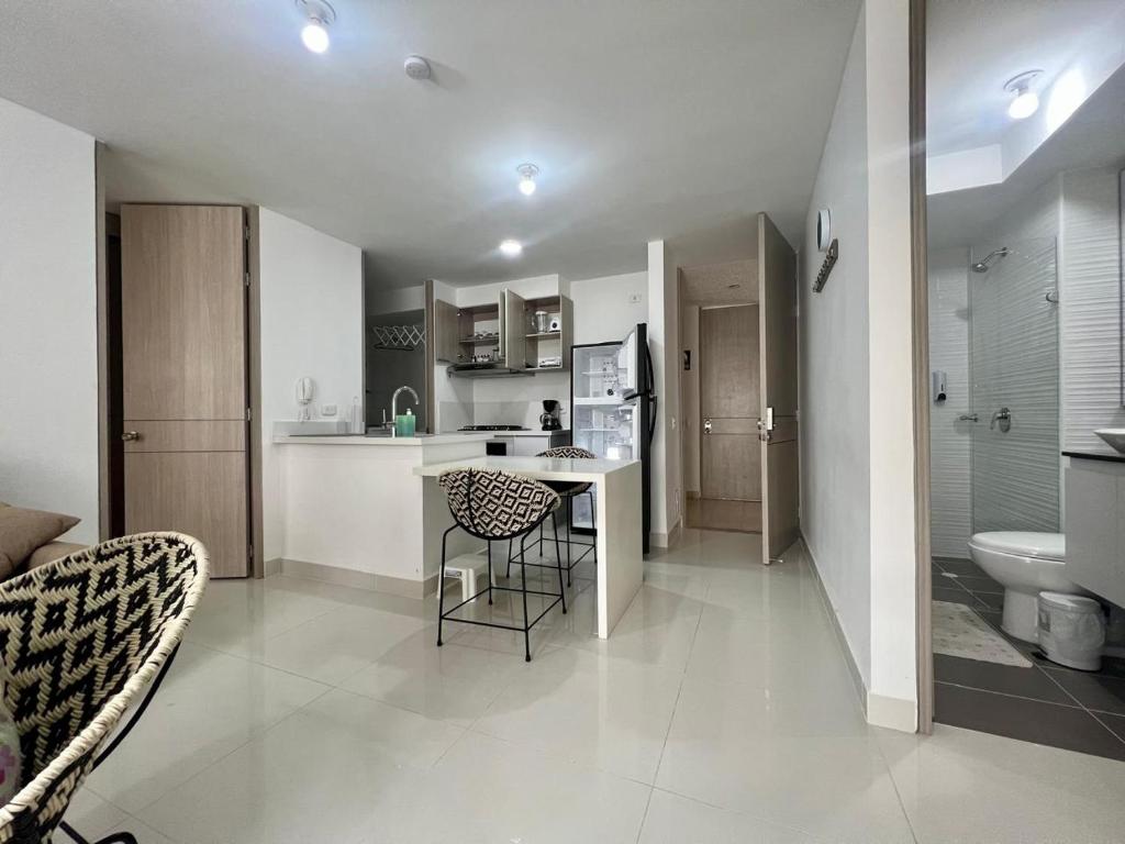 Una cocina y una sala de estar con mesa y sillas. en Escapate al sol en La Morada Peñazul apartamento BBQ, en Ricaurte