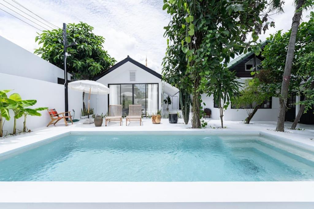 a swimming pool in front of a house at Stunning Pool Villa - In Old Town Chiang Mai Daily Housekeeping in Chiang Mai