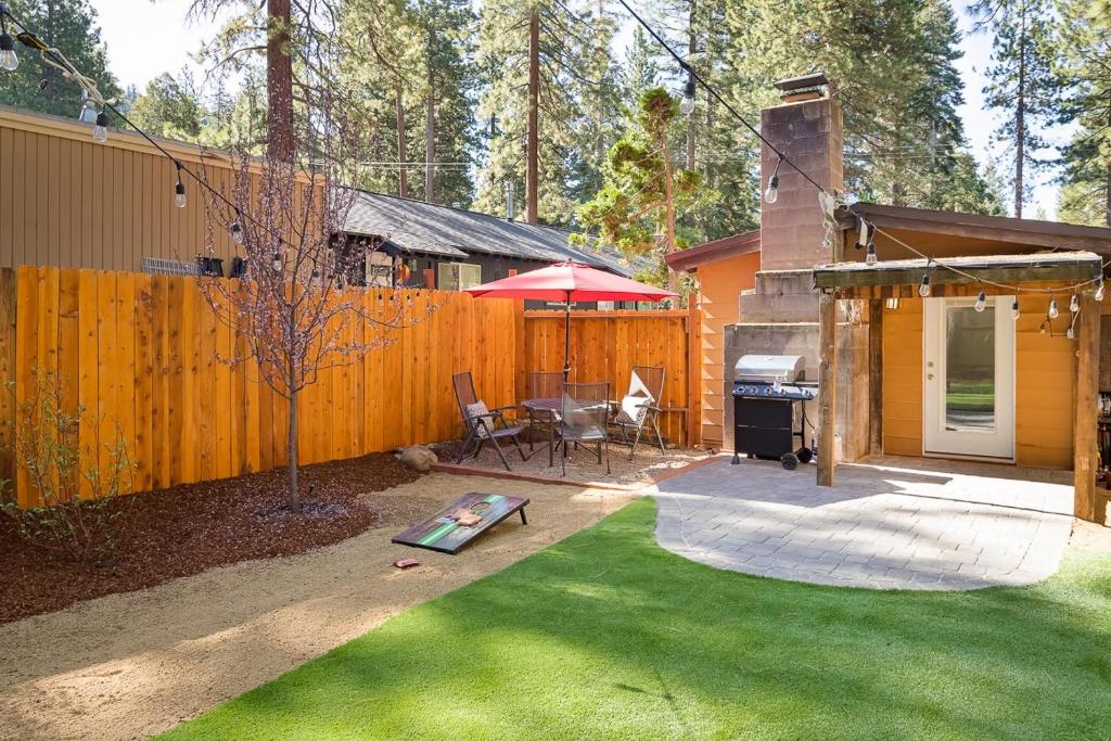 a backyard with a grill and a house with a lawn at The Brook Ave Bungalow in Kings Beach